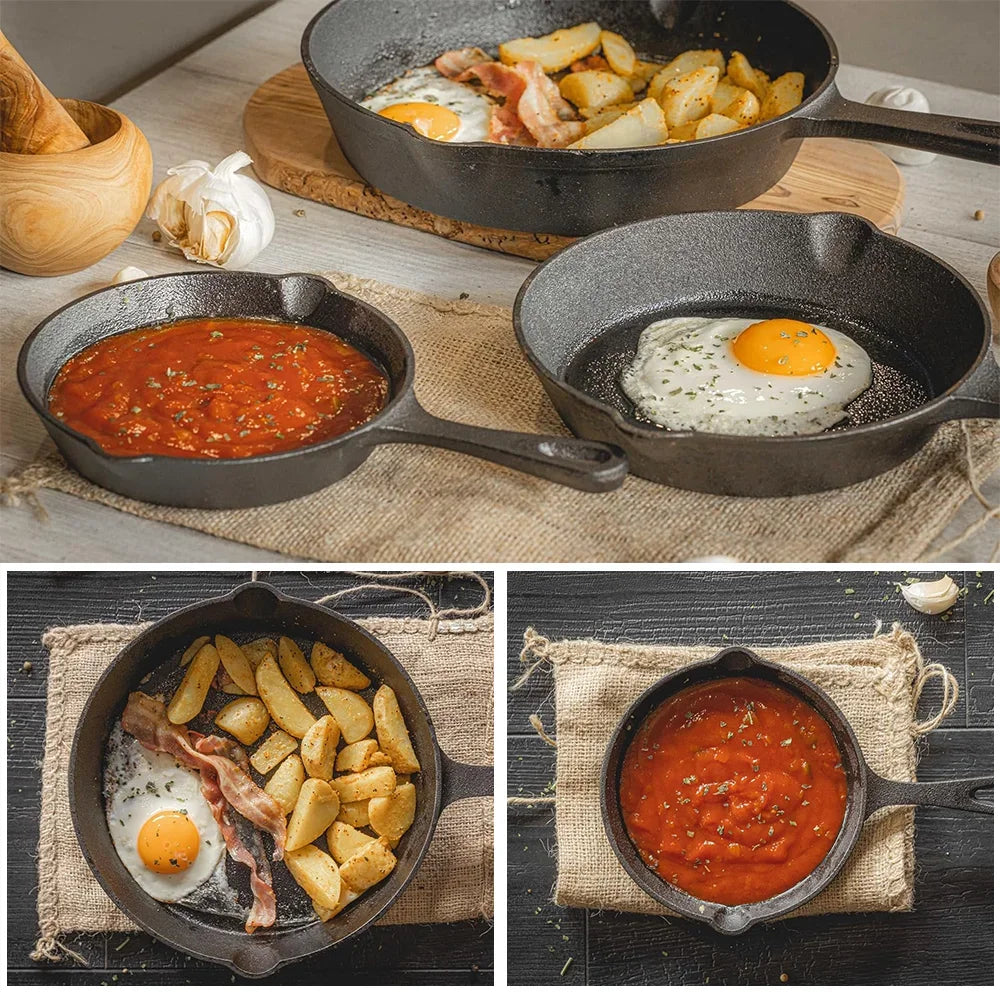 Stel cast iron skillets with fried eggs, potatoes, bacon, and tomato sauce on a rustic table
