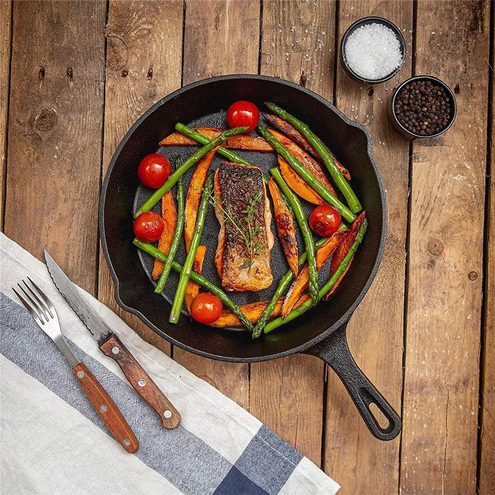Stel cast iron pan with grilled salmon, green beans, tomatoes, and carrots on rustic wood table