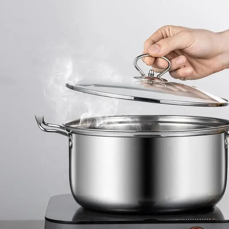 Hand lifting lid from steaming stainless steel Stel cookware pot on stovetop